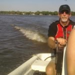 This is /photograph of Mike Davenport driving a rowing chase launch